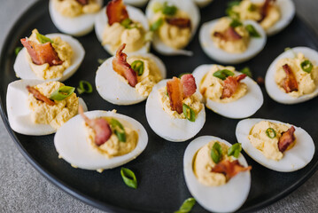 Deviled eggs garnished with bacon and green onion