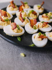 Deviled eggs garnished with bacon and green onion