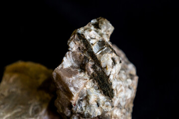 Close up of a sample from a granitic pegmatite consisting predominantly of plagioclase feldspar and biotite.