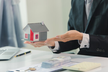 Businessman, house and condo sales agent, handing over keys to clients and signing sales or rental...