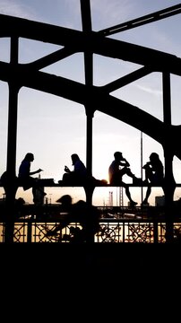 Junge Menschen Stadtbewohner genie&szlig;en den Sonnenuntergang Feierabend Freizeit Freundschaft Wochenende auf einer Br&uuml;cke vor urbaner st&auml;dtischer Kulisse Hackerbr&uuml;cke M&uuml;nchen