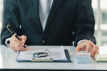 Fototapeta premium Car salesman signs car sales contract with cash and hands over keys to customer. Automotive business concept.