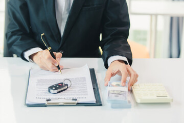 Car salesman signs car sales contract with cash and hands over keys to customer. Automotive business concept.