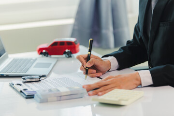 Car salesman signs car sales contract with cash and hands over keys to customer. Automotive business concept.