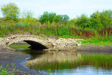 An ancient bridge on an abandoned road.