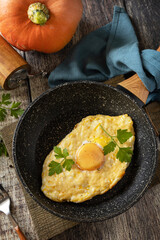 Khachapuri, baked cottage cheese pumpkin bread with cheese and egg filling on rustic wooden table.