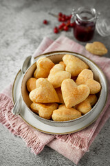 Mini doughnuts with berry jam for breakfast on the table, puff pastry heart shaped food for Valentine's Day