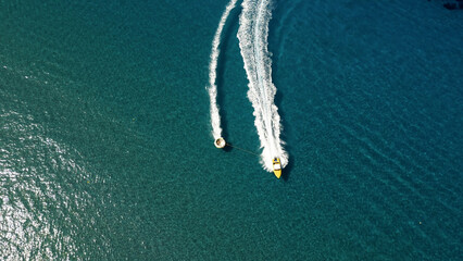 Vertical Aerial View of Deep Blue Sea Water with Yacht and Boat Leaving White Foamy Trail