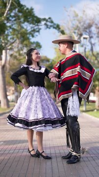 pareja de huasos chilenos bailando cueca en la plaza de la ciudad, concepto celebraci&oacute;n fiestas patrias 