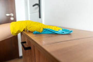 female hand wear gloves cleaning wooden furniture at house