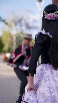 pareja de huasos bailando cueca chilena en la plaza de la ciudad