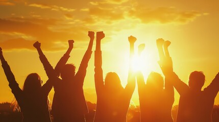 Team Celebrates Success: Group raises arms in triumph, basking in golden sunlight.