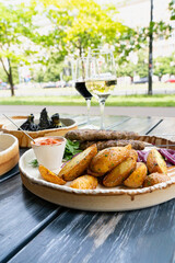 Georgian lula kebab with baked potatoes, sauce and greens. Grilled souvlaki, minced meat kebap, lamb on skewers