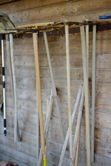 Gardening tools hanging on wooden wall in shed