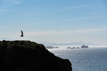 person jumping near the sea