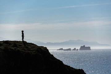 silhouette of a woman standing on a rock
