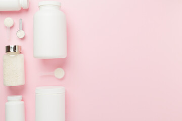 Jars with protein powder on color background, top view. Sports nutrition concept