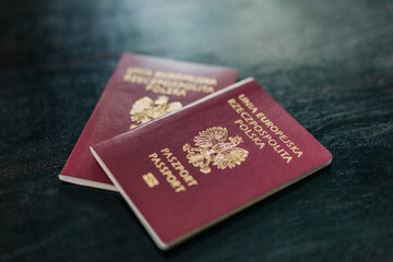 Two Polish passports are lying on a table in a home, symbolizing migration and citizenship