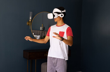 Using VR headset, asian man exploring virtual reality experience in modern room