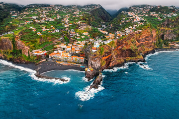 Aerial view of rough ocean with waves, volcanic beach in Ponta do Sol, Madeira, Portugal