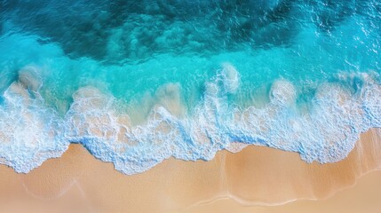 Obraz premium Drone view of a bright blue sea with waves splashing and a golden sandy beach stretching out under the sun