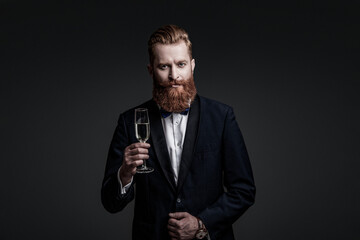 Cheering and celebrating. Elegant tuxedo man hold glass of champagne isolated on black. Celebrating success. Cheers. Bearded man with formal look. Celebrate with champagne. Tuxedo jacket