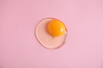 One raw egg on pink background, top view