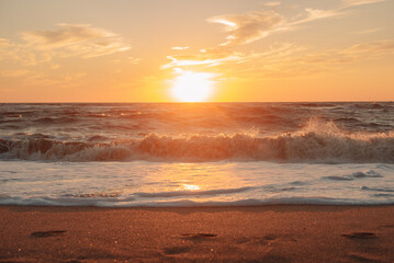 Sunset at sea during a storm. Coast with waves in sea on sunset. Waves in sea during storm and wind. Wave from the sea goes on land to the beach. Splashing Waves, Seaside.