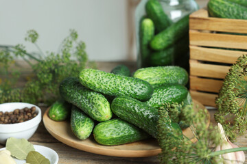 Fresh cucumbers, dill and spices on wooden table, closeup. Preparation for pickling
