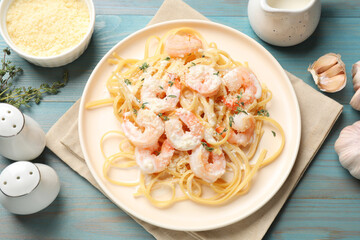 Delicious pasta with shrimps served on blue wooden table, flat lay