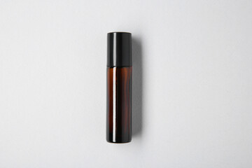 Essential oils in bottle on light background, top view