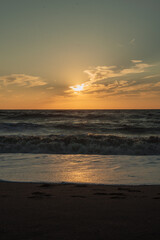 Obraz premium Sunset at sea during a storm. Coast with waves in sea on sunset. Waves in sea during storm and wind. Wave from the sea goes on land to the beach. Splashing Waves, Seaside. vertical