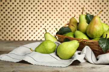 Fresh green pears and leaves with water drops on wooden table. Space for text