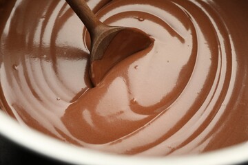 Chocolate dough and spoon in bowl, closeup