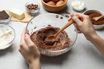 Woman making chocolate dough at light table, closeup