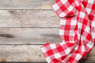 Obraz premium Crumpled tablecloth with checkered pattern on wooden table, top view. Space for text