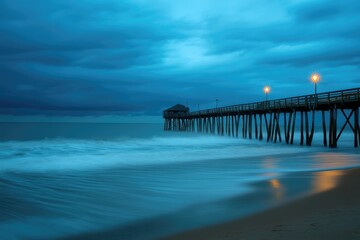 Fototapeta premium Kitty Hawk NC Nightfall: Beach Pier with Ocean and Sky View in Blue Landscape