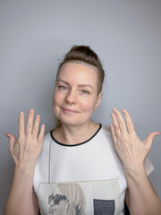 portrait of a mature woman with long hair pulled back in a ponytail and gesticulating with her hands