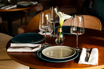 Stylish table setting in a cozy restaurant with dishes and furniture.in a minimalist style