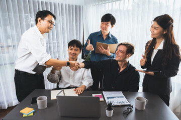 Diverse group of office employee worker shake hand after making agreement on strategic business...