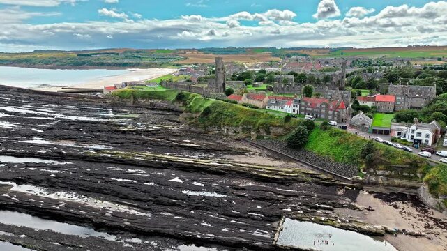 Aerial view of Coastal, episcopal castle ruins with secret passages and dungeon in Scotland. St Andrews Castle residence of Scotland's leading bishop, cathedral and town of St Andrews view.
