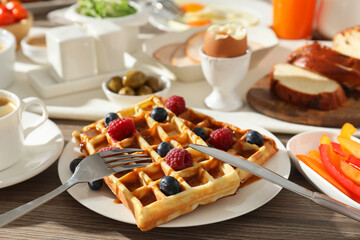 Different meals served for breakfast on wooden table