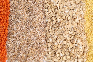 Different types of cereals and lentils as background, top view