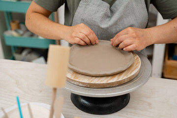 Creating ceramic products from flat sheets of clay. Using hands to model a form for a clay project. Building sides for clay products. Slab pottery.