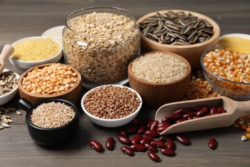 Different types of cereals, legumes and seeds on wooden table