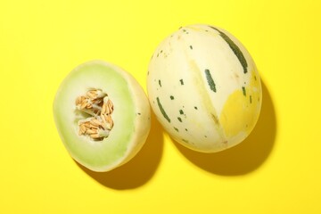 Fresh ripe honeydew melons on yellow background, top view