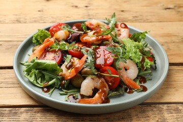 Delicious shrimp salad with vegetables on wooden table, closeup