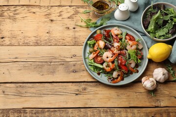Delicious shrimp salad with ingredients on wooden table, flat lay. Space for text