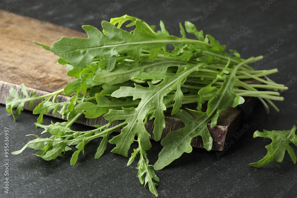 Wall mural Fresh green arugula leaves on grey textured table, closeup