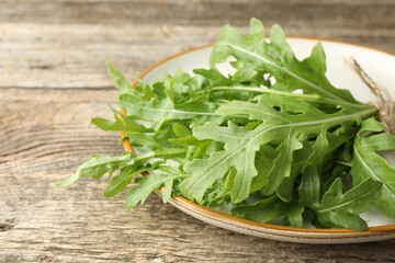 Fresh green arugula leaves on wooden table, closeup